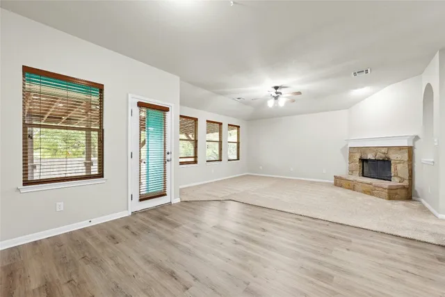 a view of an empty room with a fireplace and a window