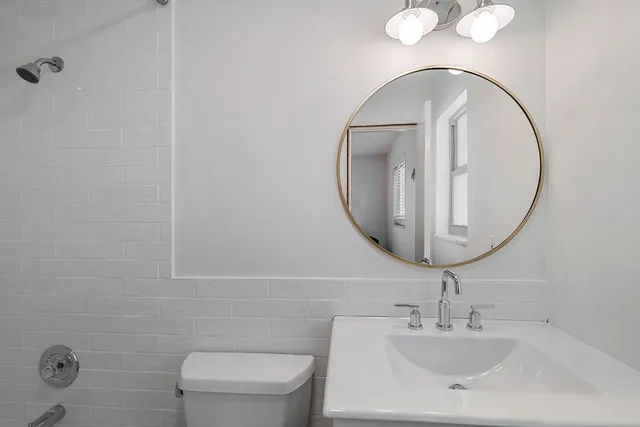 a bathroom with a toilet a sink and mirror