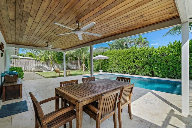 a view of a backyard with table and chairs with wooden floor and fence