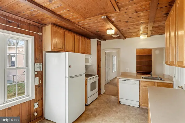 a white refrigerator freezer and a stove sitting inside of a kitchen