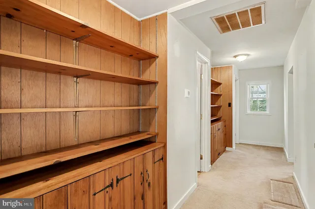 a view of a closet area with wooden floor