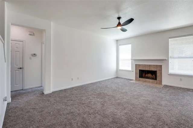 a view of empty room with a fireplace and fan