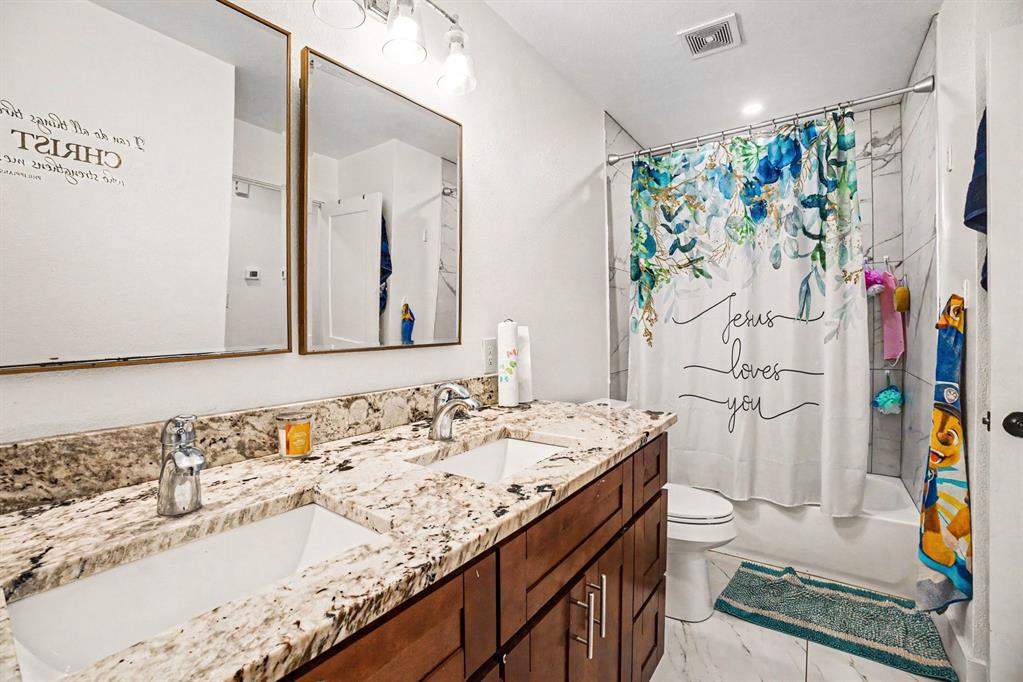 505 South Bluegrove Road Lancaster, TX 75146 - Photo 23 of 37 a bathroom with a sink a toilet and a shower curtain