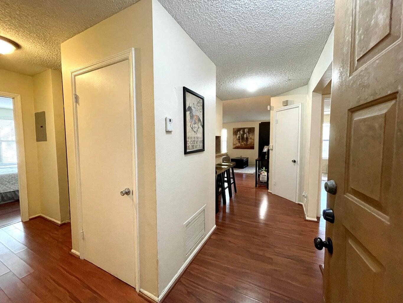 a view of a hallway with wooden floor and furniture