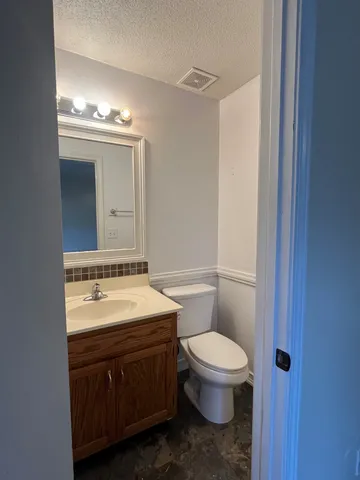a bathroom with a toilet a sink and mirror
