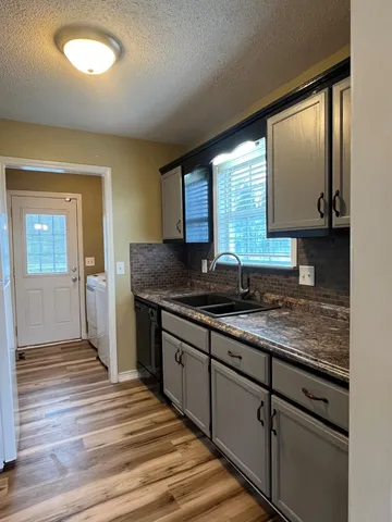 a kitchen with granite countertop wooden cabinets a sink and dishwasher