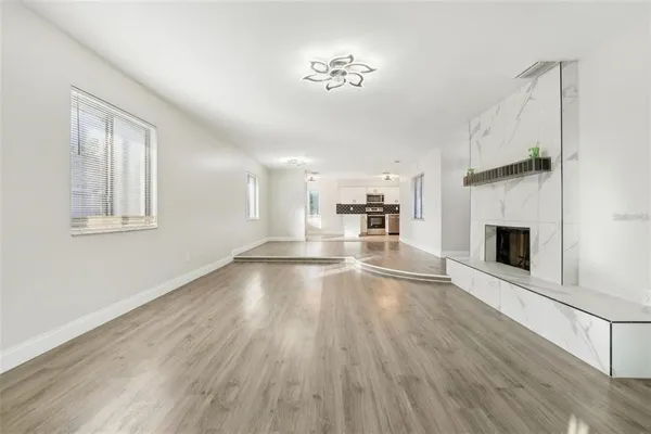 a view of a livingroom with wooden floor a fireplace and window
