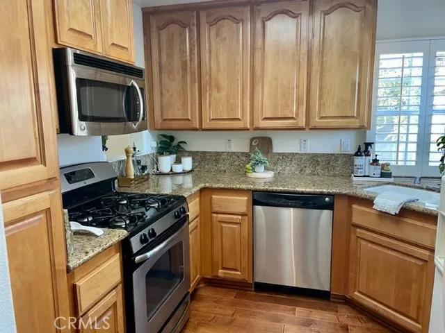 a kitchen with granite countertop white cabinets and stainless steel appliances