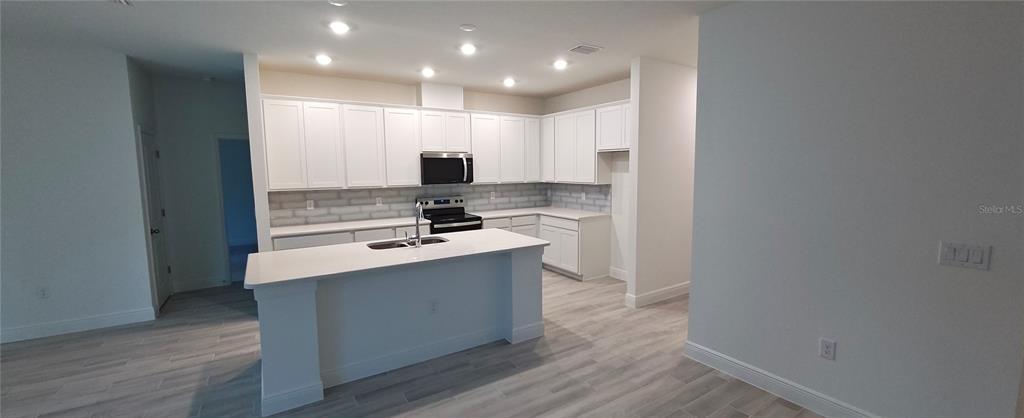 3 Undermount Path East Palm Coast, FL 32164 - Photo 2 of 13 a kitchen with kitchen island stainless steel appliances a sink and a stove top oven