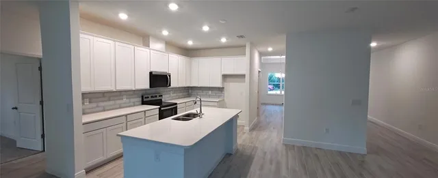a kitchen with a sink cabinets and wooden floor
