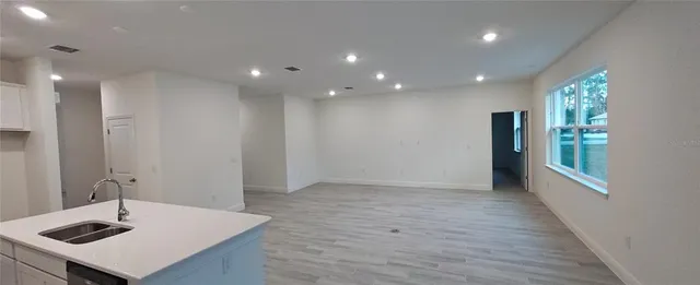 a view of an empty room with a kitchen