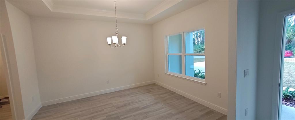 3 Undermount Path East Palm Coast, FL 32164 - Photo 8 of 13 an empty room with windows and chandelier