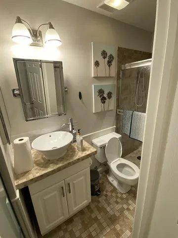 a bathroom with a granite countertop sink toilet and shower