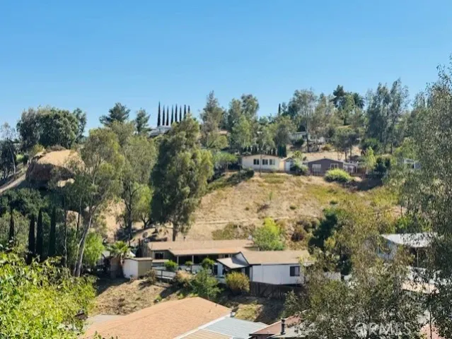 a view of a house with a yard and a large tree