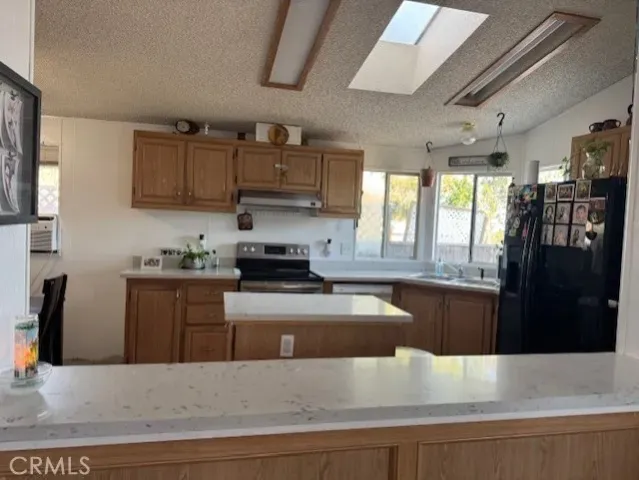 a kitchen with kitchen island granite countertop a sink table and chairs