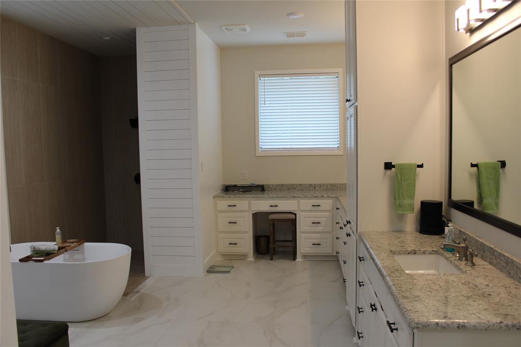 333 Renaissance Lane Heath, TX 75032 - Photo 32 of 35 Spacious bath featuring a freestanding tub, separate shower, double vanity with integrated sinks, granite countertops, and extensive white cabinetry