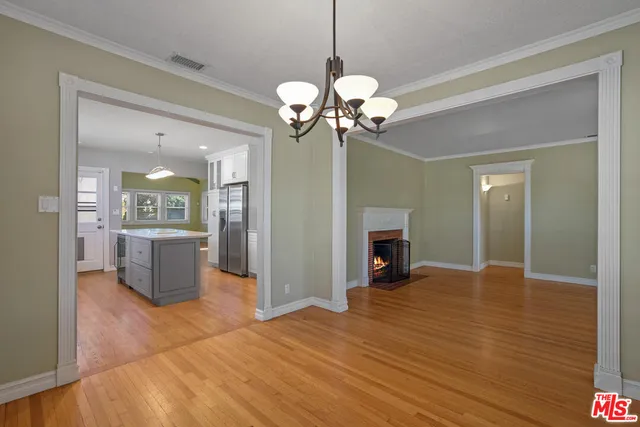 a view of a livingroom with a fireplace a chandelier and wooden floor
