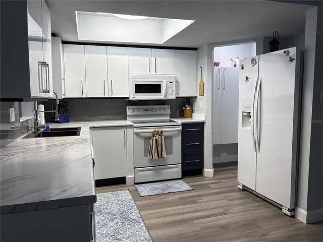 a kitchen with stainless steel appliances a refrigerator sink and cabinets