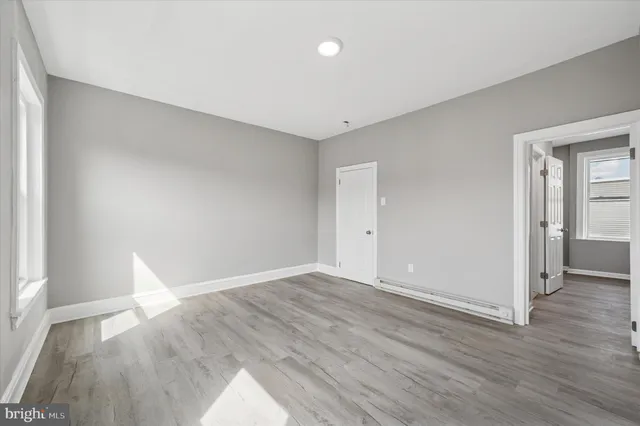a view of empty room with wooden floor