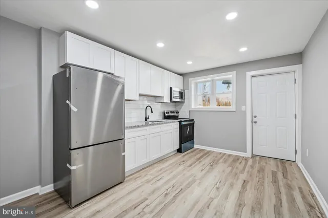 a kitchen with refrigerator cabinets and wooden floor