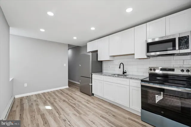 a kitchen with stainless steel appliances a stove sink and microwave