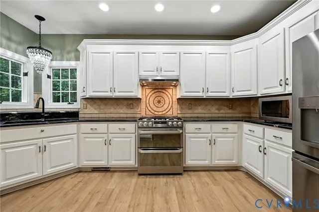 a kitchen with granite countertop white cabinets and white appliances