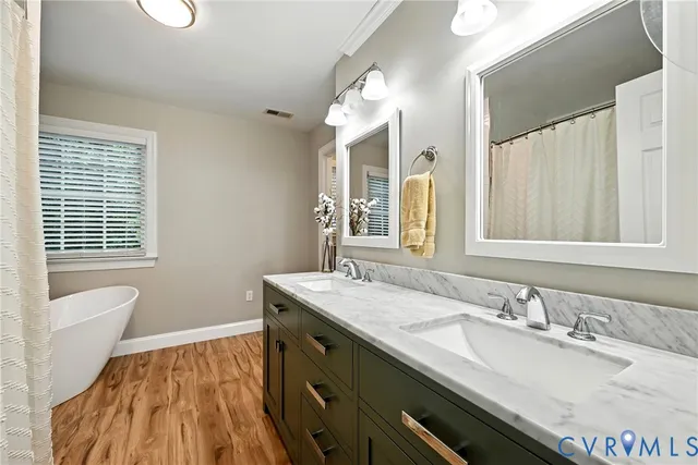 a bathroom with a granite countertop sink a mirror and a bathtub