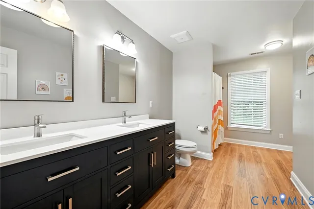 a bathroom with a double vanity sink and a mirror