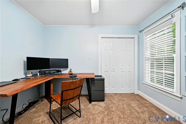 a view of a workspace with furniture and a window
