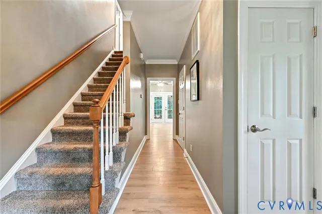 a view of staircase with lots of frames on wall and windows