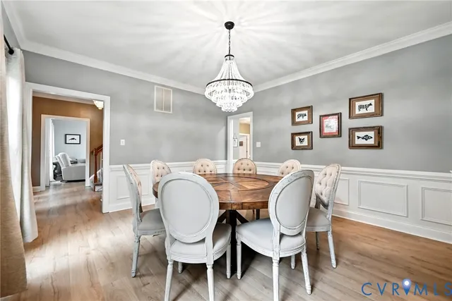 a view of a dining room with furniture wooden floor and chandelier