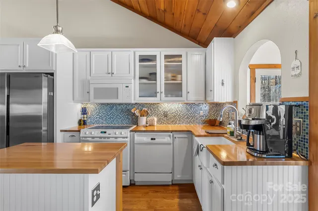 a kitchen with granite countertop a sink a counter space appliances and cabinets