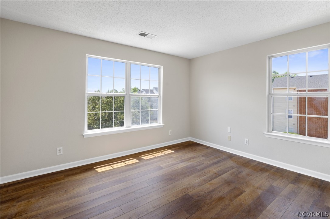 910 Masters Row, Unit J Glen Allen, VA 23059 - Photo 13 of 17 a view of an empty room with wooden floor and a window
