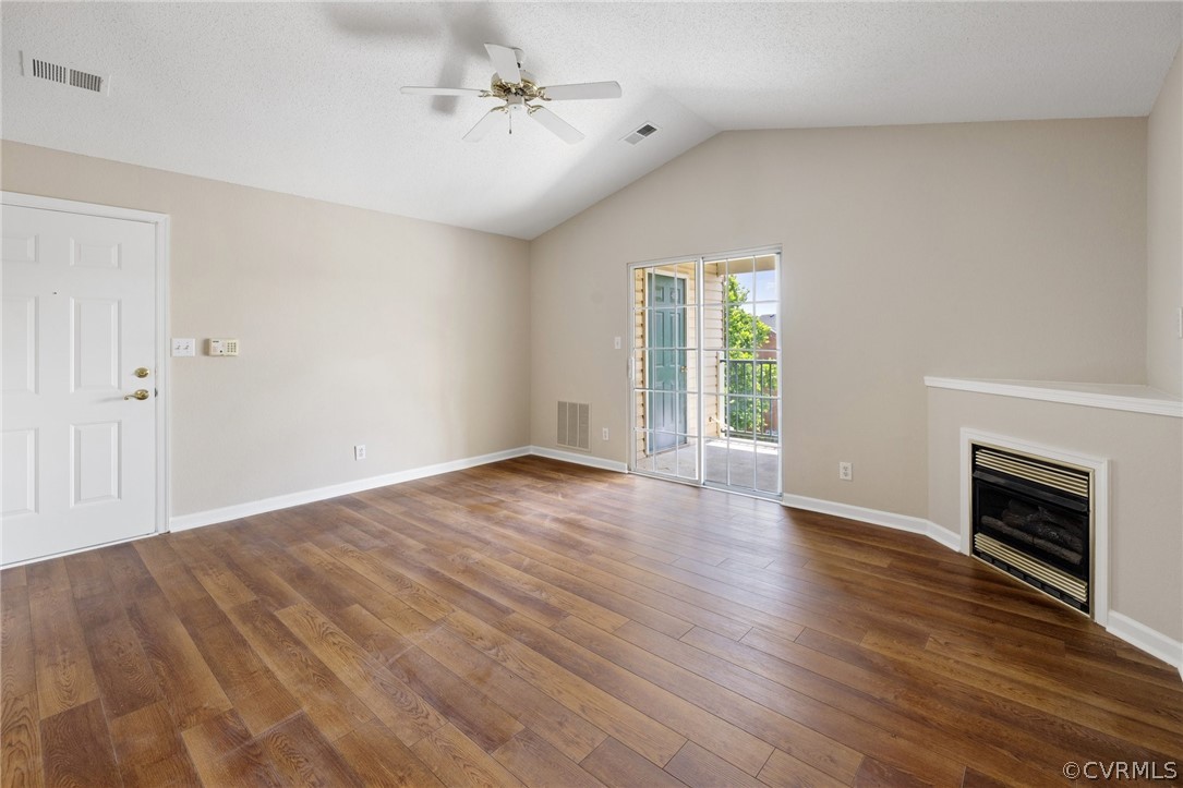 910 Masters Row, Unit J Glen Allen, VA 23059 - Photo 4 of 17 a view of an empty room with wooden floor fireplace and a window