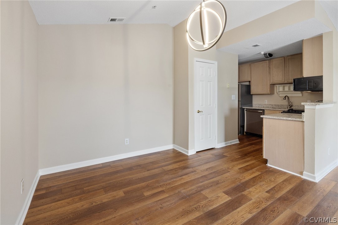 910 Masters Row, Unit J Glen Allen, VA 23059 - Photo 5 of 17 a view of kitchen with stainless steel appliances granite countertop a stove a sink and white cabinets with wooden floor