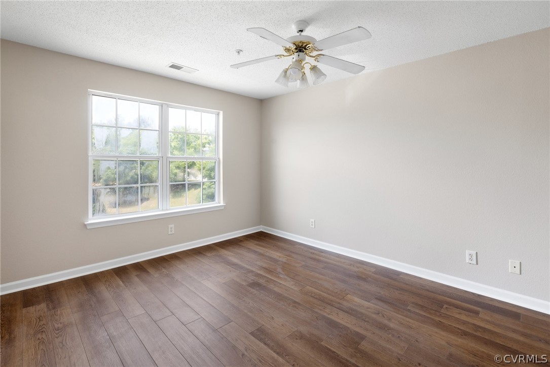 910 Masters Row, Unit J Glen Allen, VA 23059 - Photo 10 of 17 an empty room with wooden floor chandelier fan and windows