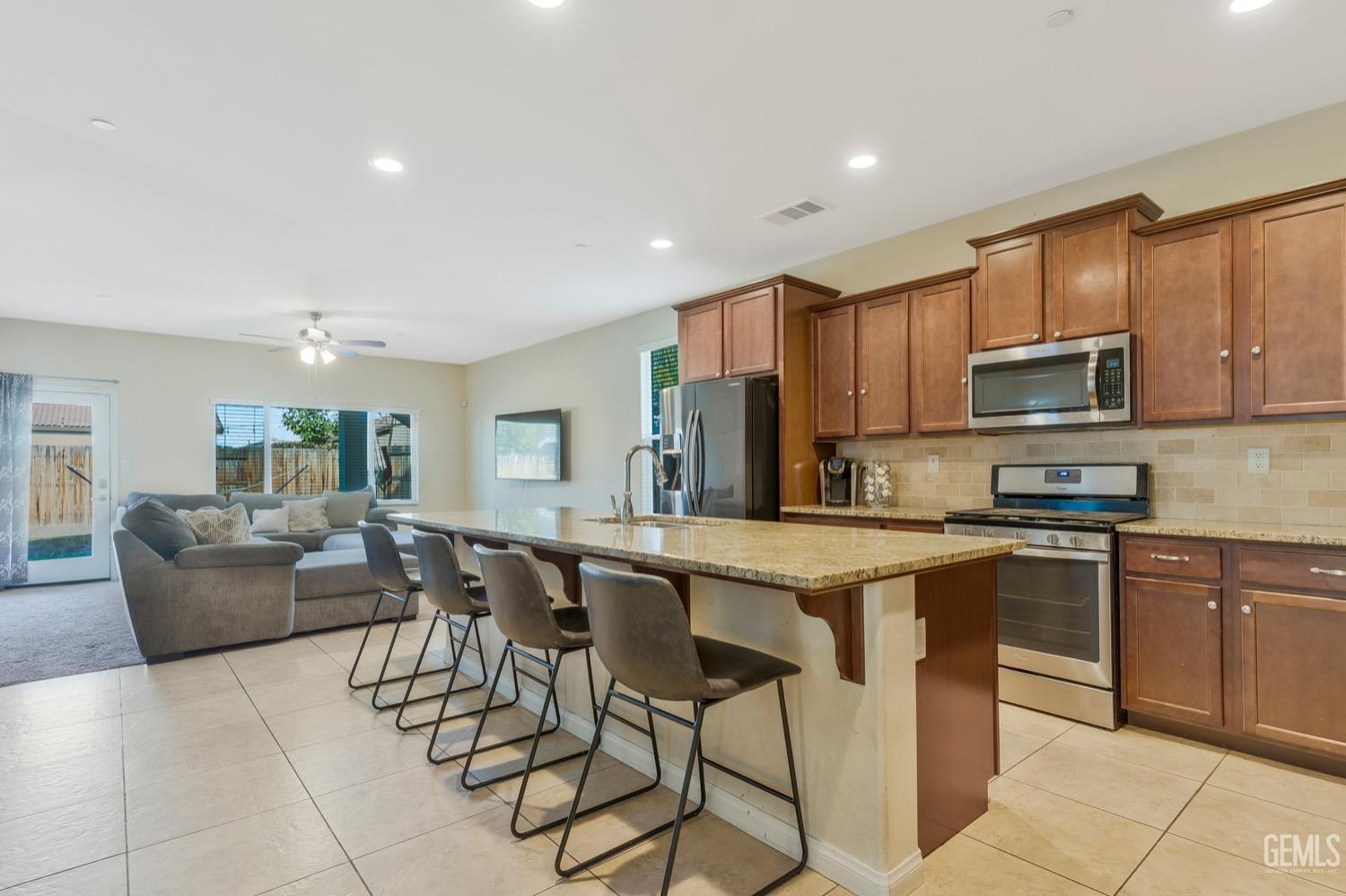 Undisclosed Address Bakersfield, CA 93313 - Photo 8 of 35 a kitchen with stainless steel appliances granite countertop a table and chairs in it