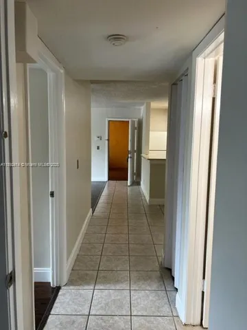 a hallway with closet and bathroom