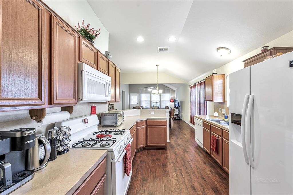 3203 Dale Ridge Trail Houston, TX 77084 - Photo 7 of 33 Spacious kitchen with classic wood cabinetry, white appliances, and ample countertop space.