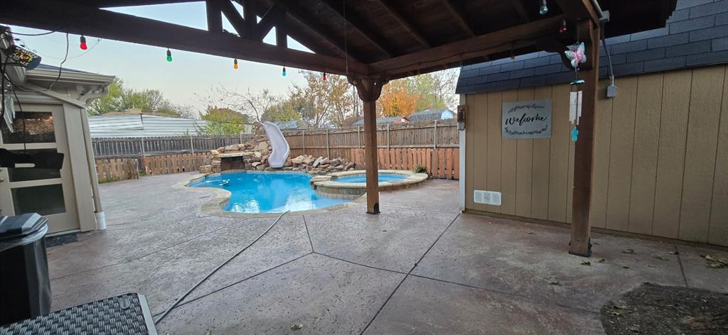 509 Royal Valley Road Grand Prairie, TX 75052 - Photo 6 of 22 a living room with furniture a flat screen tv and a floor to ceiling window