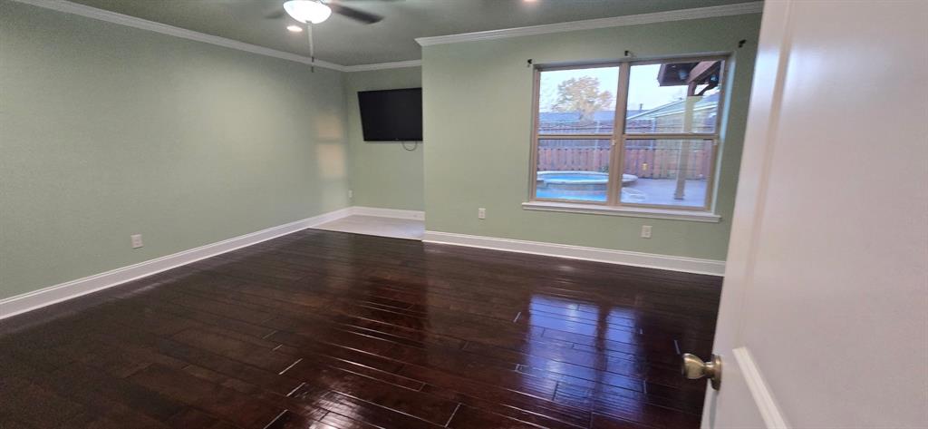 509 Royal Valley Road Grand Prairie, TX 75052 - Photo 7 of 22 an empty room with wooden floor and windows