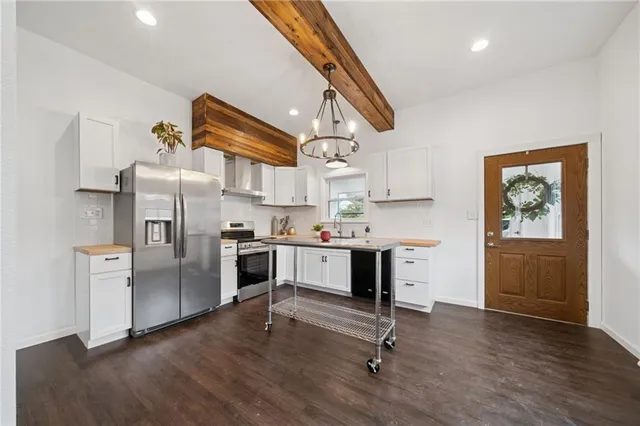 a kitchen with stainless steel appliances a stove a refrigerator and a refrigerator
