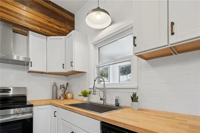a kitchen with stainless steel appliances granite countertop a sink a stove and cabinets