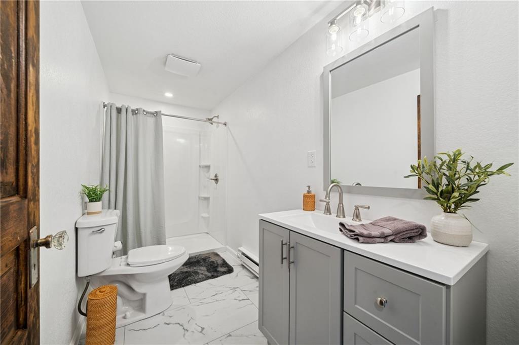 124 Oak Street Yukon, PA 15698 - Photo 22 of 35 a bathroom with a granite countertop sink a toilet and shower