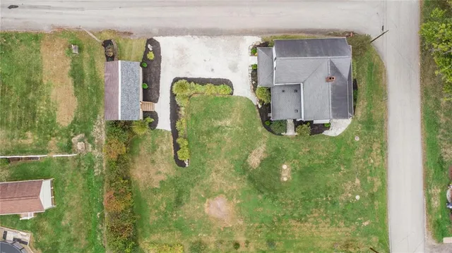 an aerial view of a house with garden space and street view
