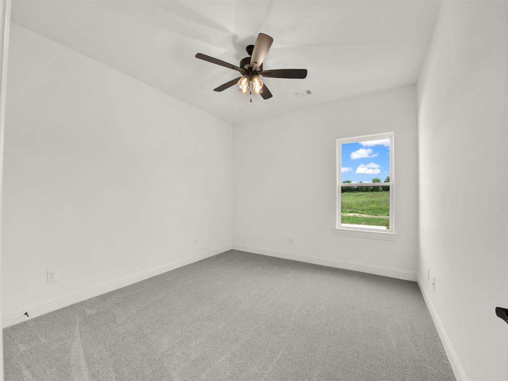 143 Desperado Way Weatherford, TX 76088 - Photo 33 of 36 Carpeted spare room featuring ceiling fan and baseboards