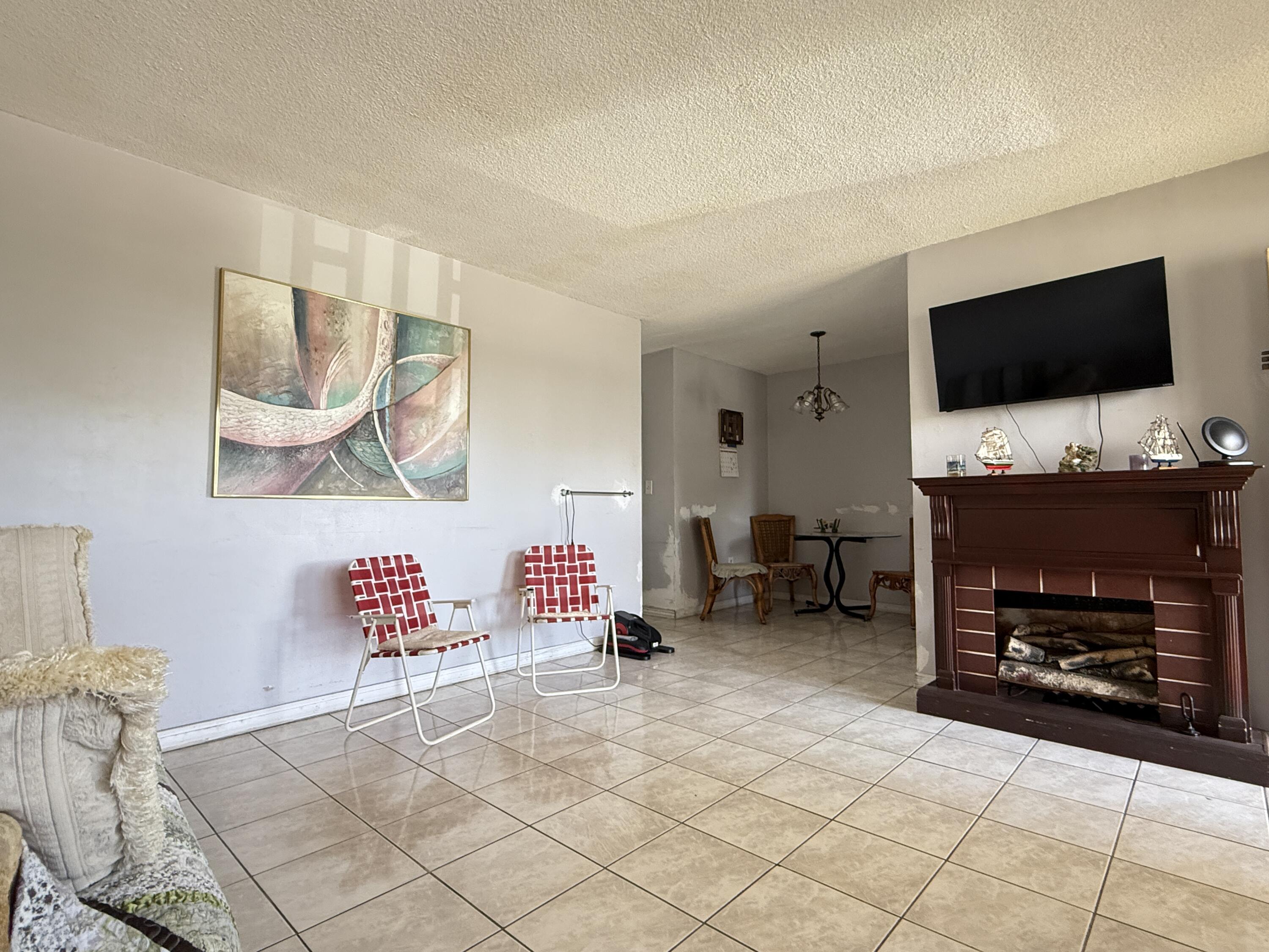17001 Northeast 13th Avenue, Unit 205 Miami, FL 33162 - Photo 3 of 14 a living room with furniture and a flat screen tv