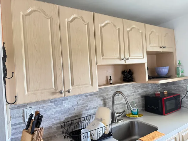 a kitchen with granite countertop a sink a stove and a wooden cabinets