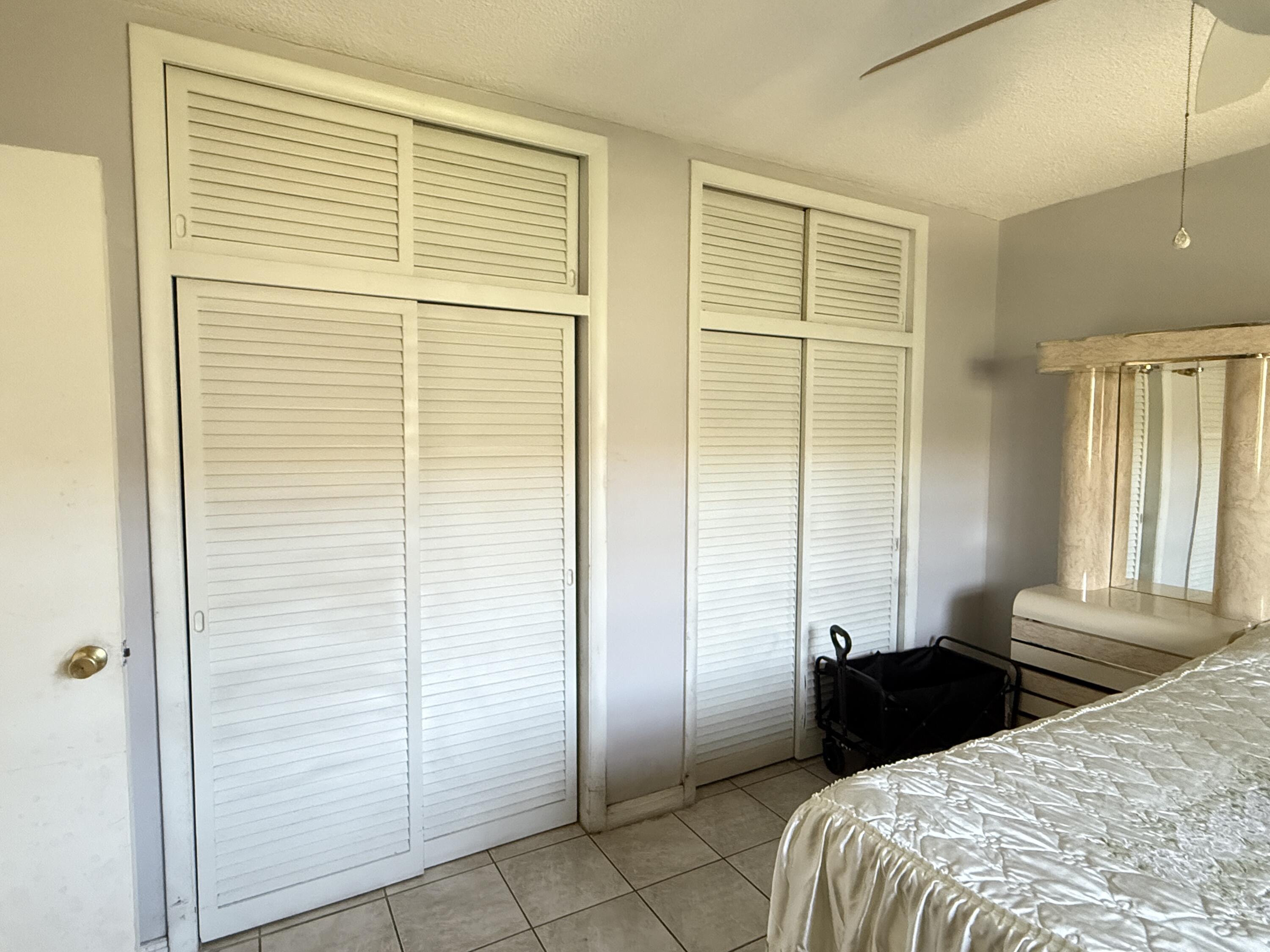 17001 Northeast 13th Avenue, Unit 205 Miami, FL 33162 - Photo 6 of 14 a bedroom with a bed and a walk in closet
