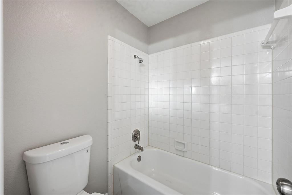 705 Timberoaks Drive Azle, TX 76020 - Photo 18 of 27 a white bath tub sitting next to a white toilet and a shower